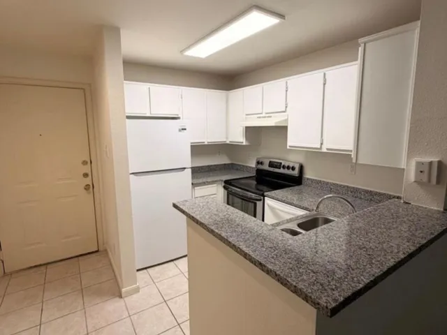 a kitchen with a refrigerator and a stove