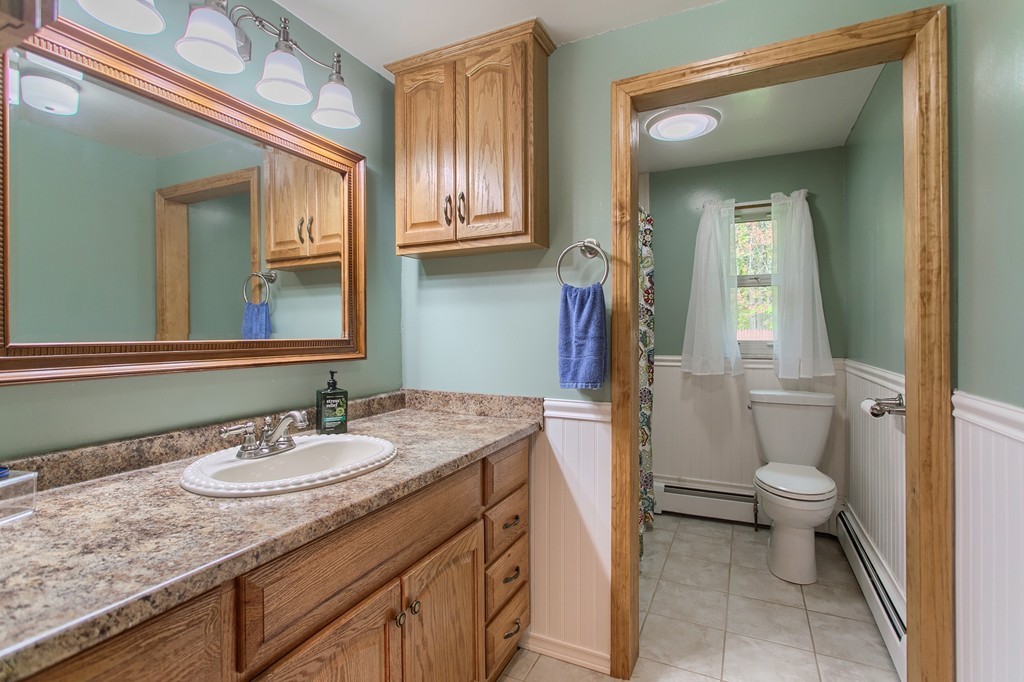 30 Center Street Ashburnham, MA 01430 - Photo 17 of 30 a bathroom with a granite countertop sink a toilet and a mirror