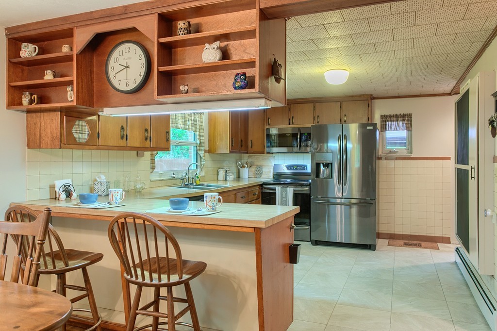 30 Center Street Ashburnham, MA 01430 - Photo 4 of 30 a kitchen with stainless steel appliances granite countertop a table chairs a refrigerator and a stove