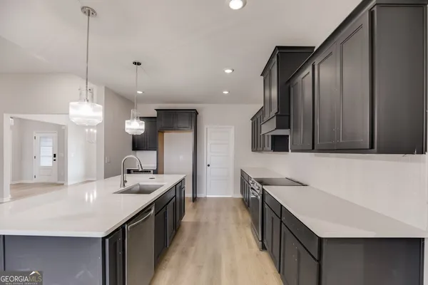 a kitchen with sink stove and refrigerator