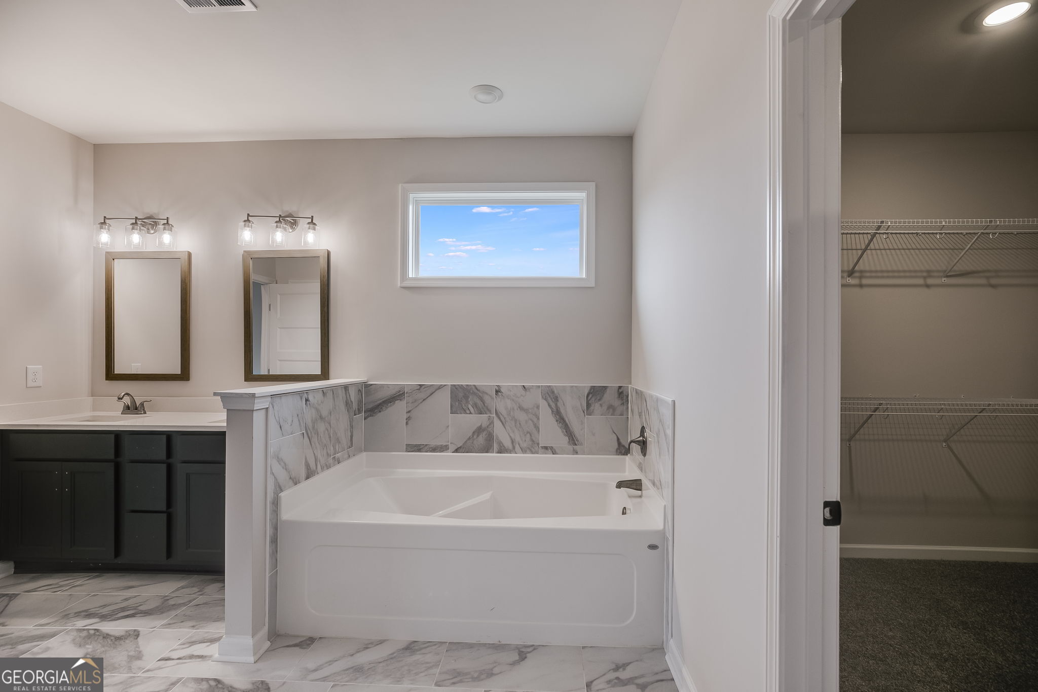 3356 Veal Road Roopville, GA 30170 - Photo 24 of 45 a bathroom with a bathtub and a double vanity sink