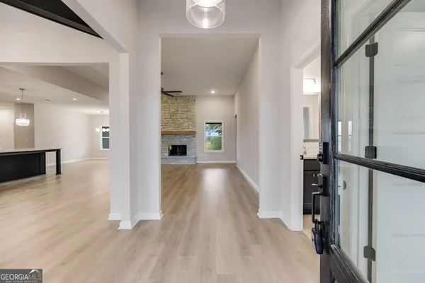 an empty room with wooden floor a fireplace and windows