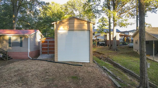 a view of a small yard in front of a house with a large tree