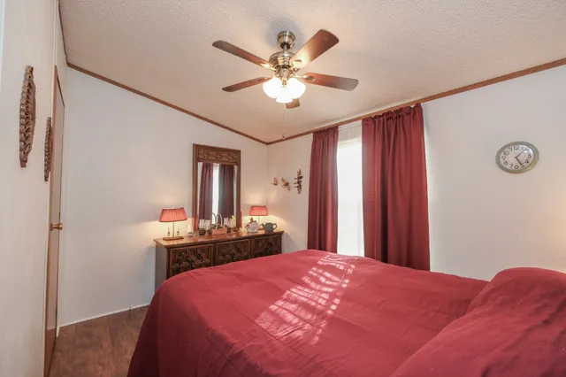 a bedroom with a bed and a dresser with mirror