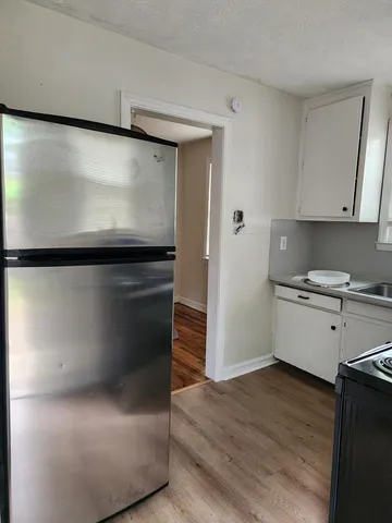 a kitchen with granite countertop white cabinets and white appliances