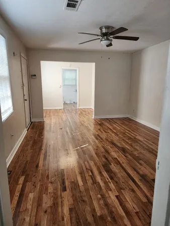 a view of empty room with wooden floor