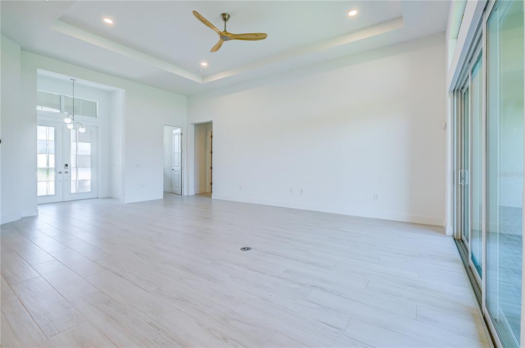 8218 Nevis Run Lakewood Ranch, FL 34202 - Photo 11 of 48 an empty room with wooden floor and windows