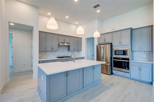 a kitchen with a sink stainless steel appliances and cabinets