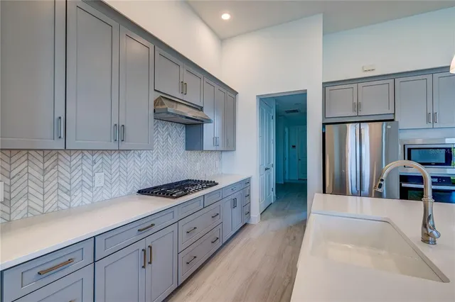 a kitchen with stainless steel appliances granite countertop a sink stove and refrigerator