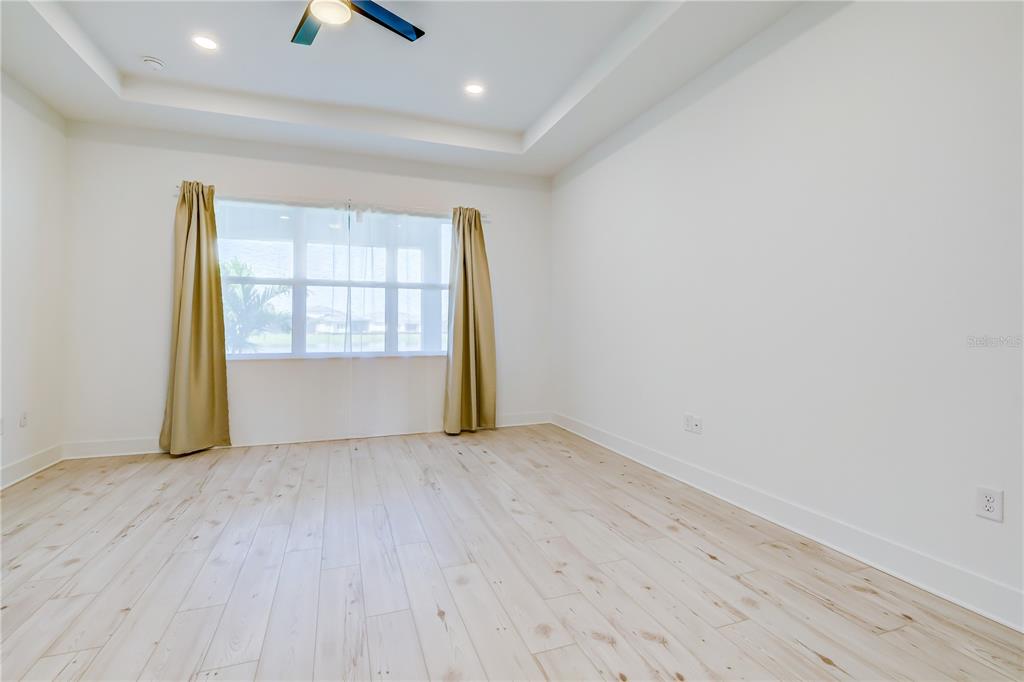 8218 Nevis Run Lakewood Ranch, FL 34202 - Photo 17 of 48 an empty room with wooden floor and windows