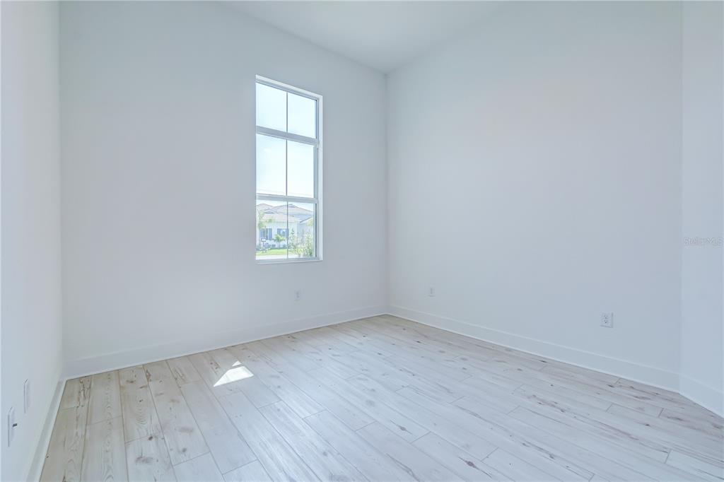 8218 Nevis Run Lakewood Ranch, FL 34202 - Photo 25 of 48 an empty room with wooden floor and windows