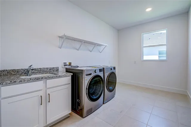 a utility room with sink dryer and washer