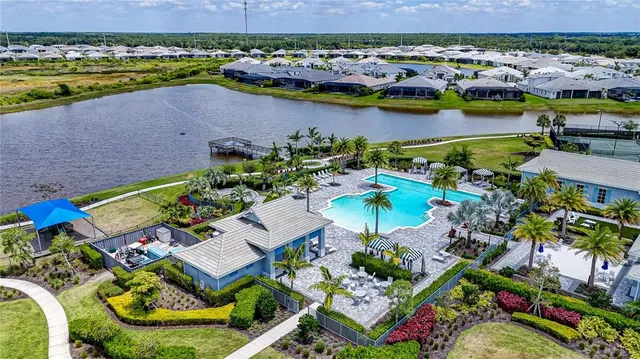 an aerial view of residential houses with outdoor space and lake view