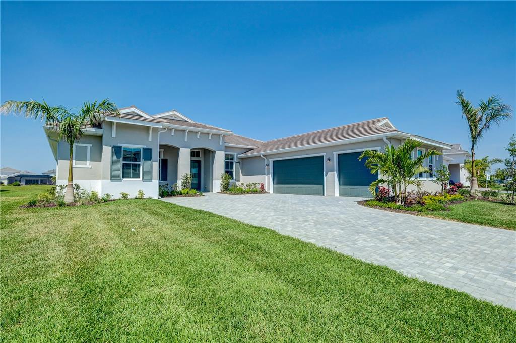 8218 Nevis Run Lakewood Ranch, FL 34202 - Photo 36 of 48 a front view of a house with a yard and potted plants