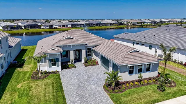 an aerial view of a house with a garden and lake view