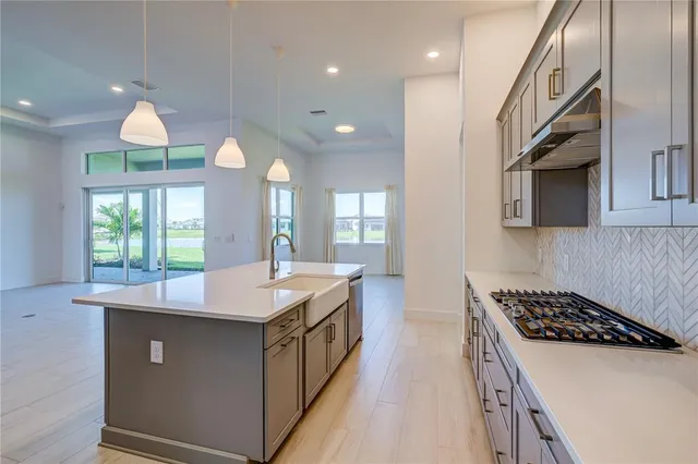 a kitchen with kitchen island granite countertop a sink a stove and a wooden floors