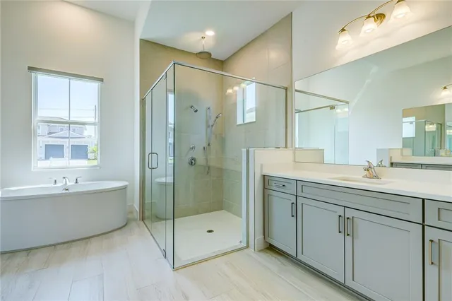 a spacious bathroom with a shower sink double vanity and bathtub