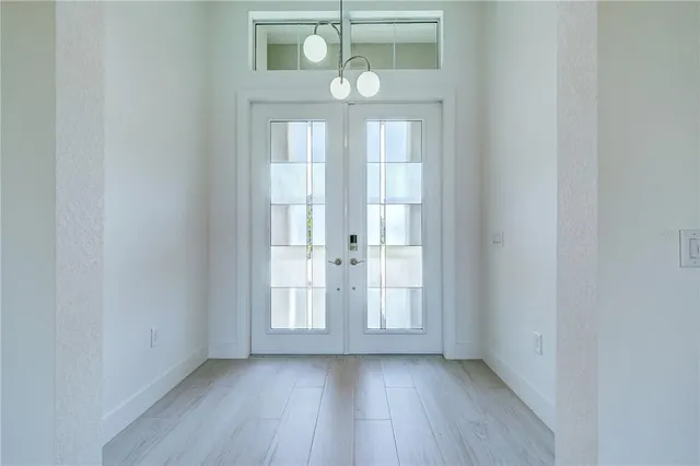 a view of an empty room with wooden floor and window