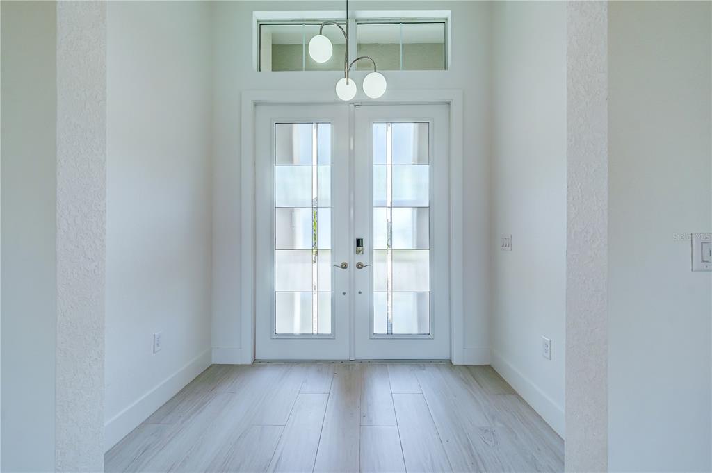 8218 Nevis Run Lakewood Ranch, FL 34202 - Photo 8 of 48 a view of an empty room with wooden floor and window