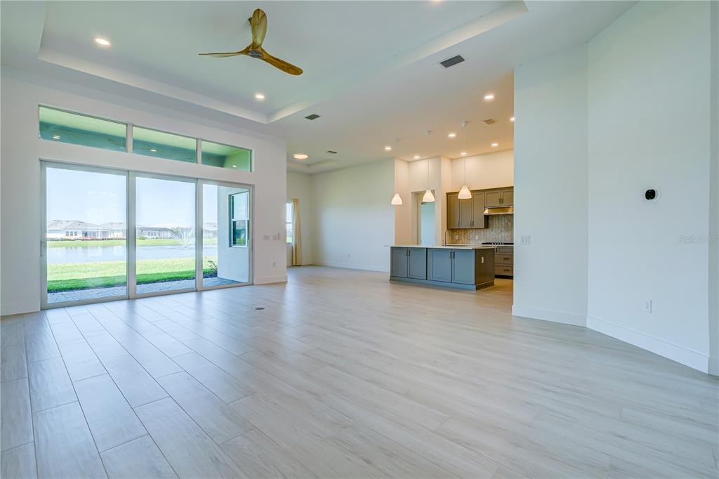 8218 Nevis Run Lakewood Ranch, FL 34202 - Photo 9 of 48 a view of an empty room with wooden floor and a window