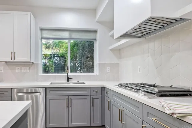 a kitchen with granite countertop a sink stove and cabinets