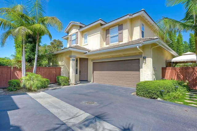 a view of a white house with large windows and a yard