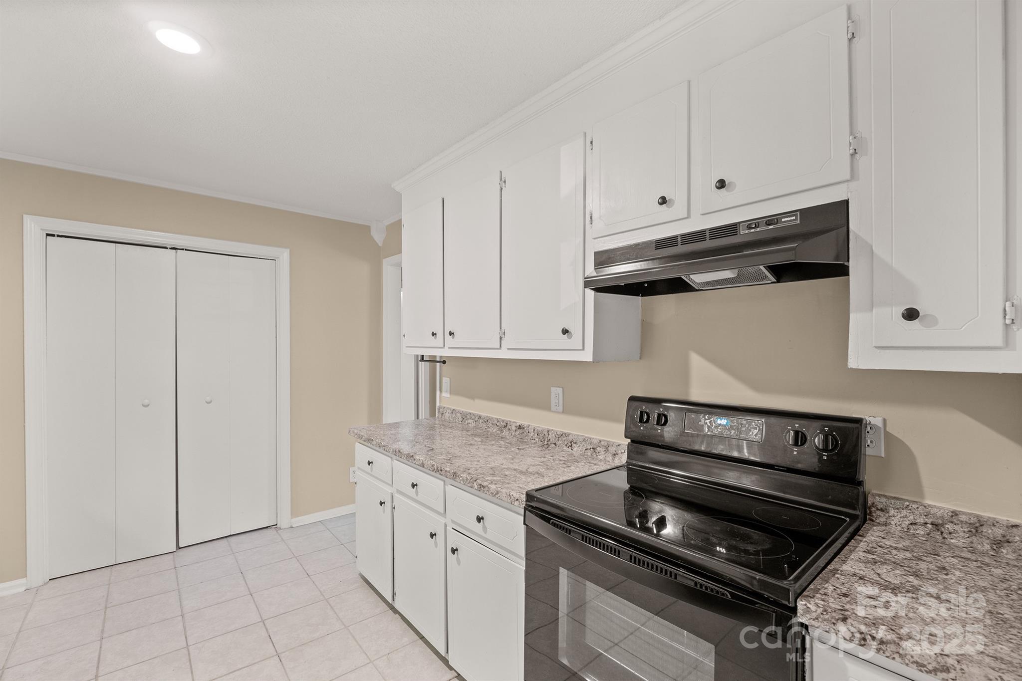 1052 Palmyra Drive Fort Mill, SC 29708 - Photo 10 of 26 a kitchen with granite countertop white cabinets and a stove top oven
