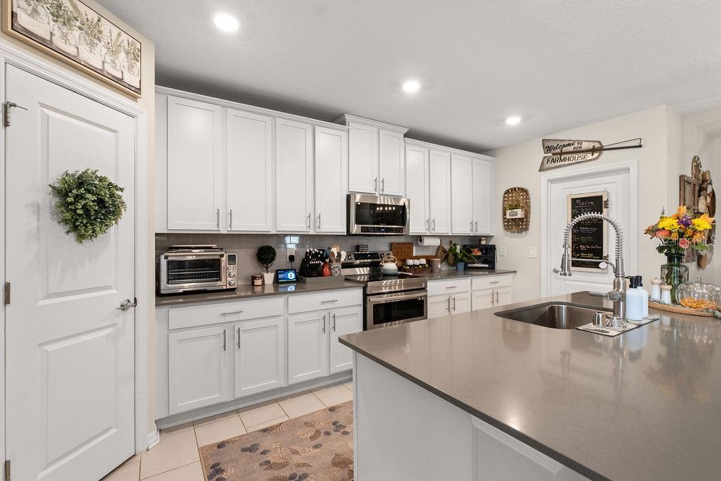 2821 Muller Oak Loop Ocoee, FL 34761 - Photo 13 of 45 a kitchen with stainless steel appliances granite countertop a sink a stove and a refrigerator