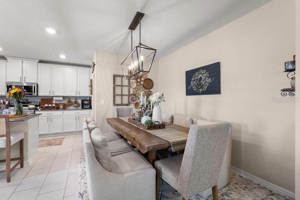2821 Muller Oak Loop Ocoee, FL 34761 - Photo 16 of 45 a kitchen with stainless steel appliances kitchen island granite countertop a table chairs and a refrigerator