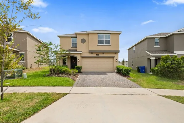a front view of a house with a yard and a garage
