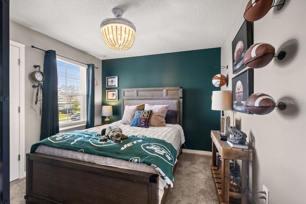 2821 Muller Oak Loop Ocoee, FL 34761 - Photo 29 of 45 a bedroom with a bed and a chandelier