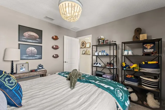 a bedroom with a bed and a chandelier