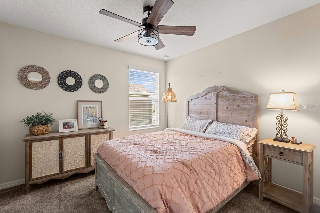 2821 Muller Oak Loop Ocoee, FL 34761 - Photo 31 of 45 a bedroom with a bed and a chandelier