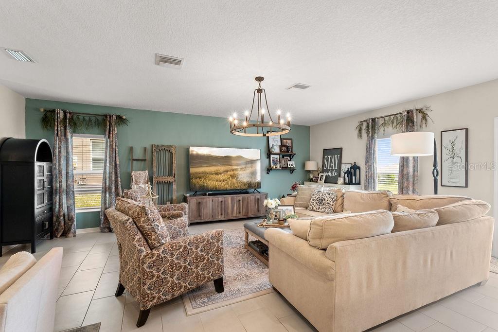 2821 Muller Oak Loop Ocoee, FL 34761 - Photo 10 of 45 a living room with furniture a flat screen tv and a chandelier