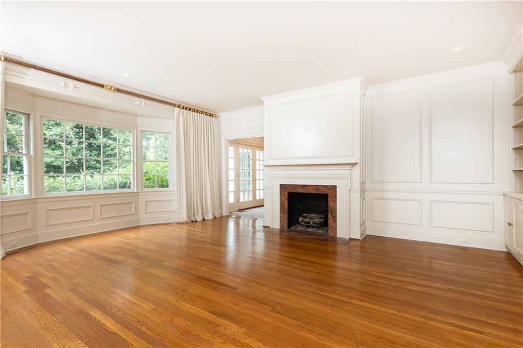 3384 Rilman Road Northwest Atlanta, GA 30327 - Photo 12 of 68 a view of an empty room with wooden floor fireplace and a window