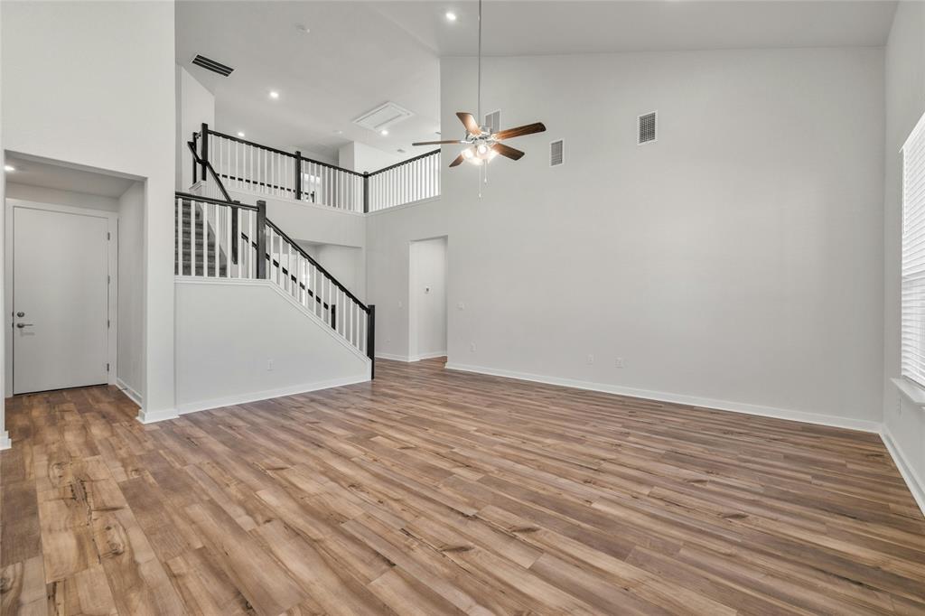 113 Shadow Oak Cove Georgetown, TX 78628 - Photo 7 of 40 A spacious common area with soaring ceilings and rich hardwood flooring, perfect for gatherings.