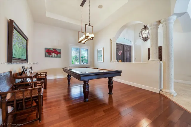 a living room with furniture a chandelier and a flat screen tv