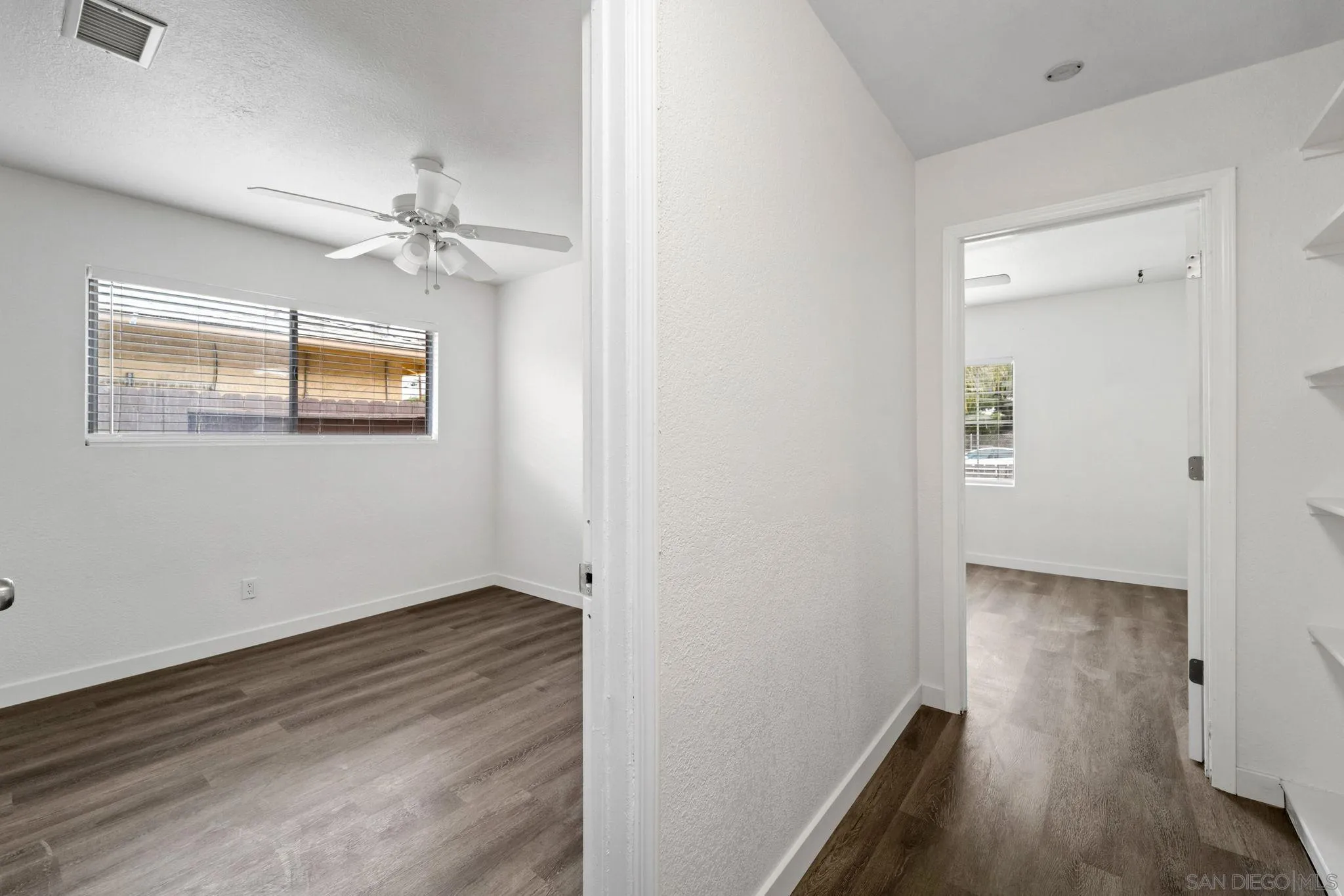 564 Broadview Street Spring Valley, CA 91977 - Photo 28 of 53 an empty room with wooden floor chandelier fan and windows