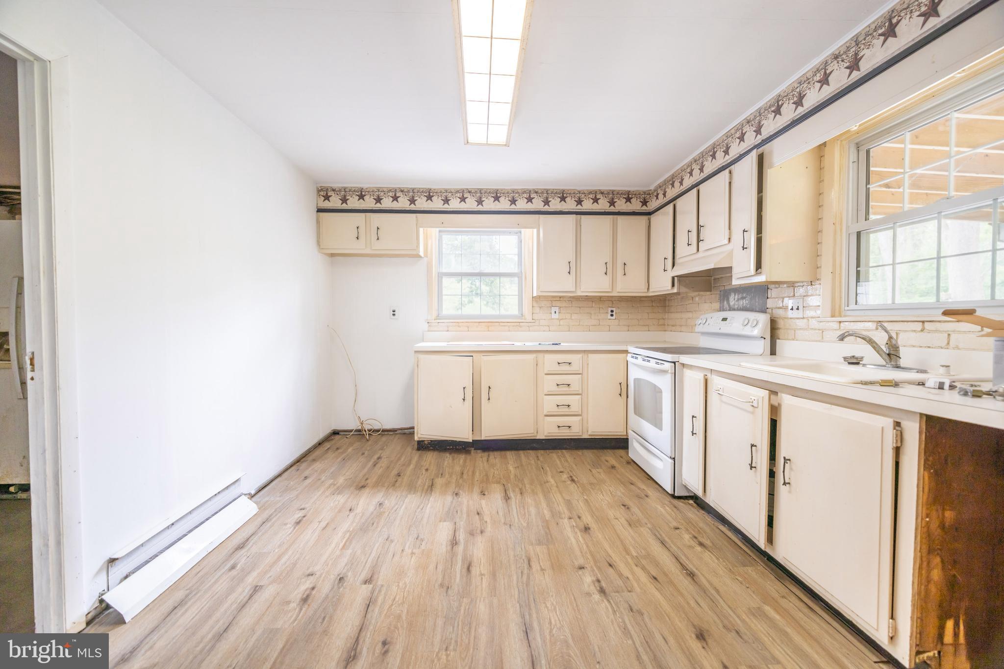 160 Stoney Bank Road Glen Mills, PA 19342 - Photo 11 of 46 a kitchen with a sink wooden floor a window and stainless steel appliances