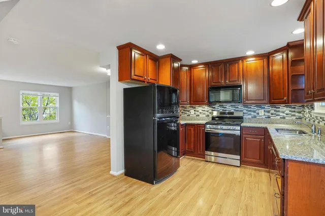 a kitchen with stainless steel appliances granite countertop a refrigerator stove and oven