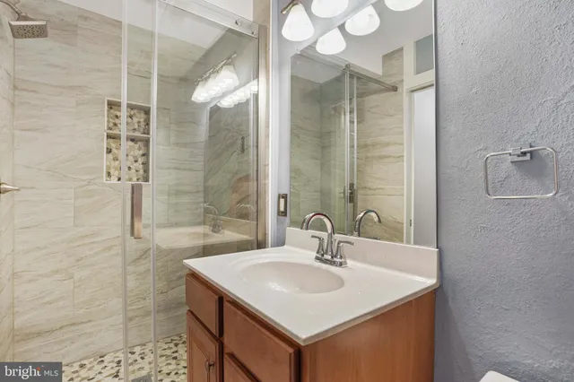 a bathroom with a sink vanity toilet and shower
