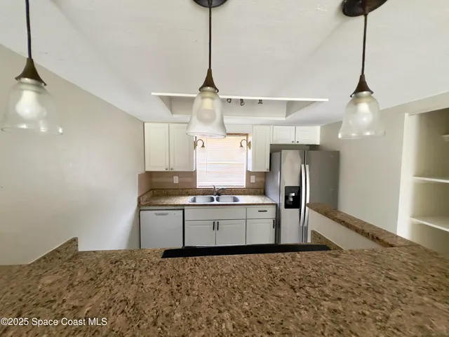 a kitchen with stainless steel appliances granite countertop a sink a stove and a refrigerator