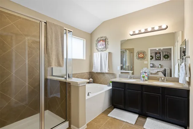 a large bathroom with a double vanity sink a mirror and a bathtub
