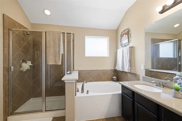 a bathroom with a tub sink shower and mirror