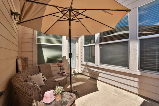 a patio with a table and chairs under an umbrella