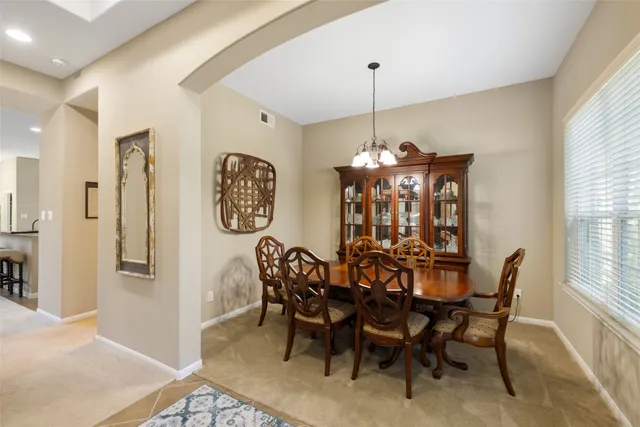 a view of a dining room with furniture and chandelier