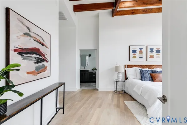 a bedroom with a bed and a painting on the wall