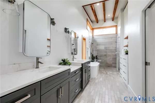 a bathroom with a granite countertop sink a toilet a mirror and shower