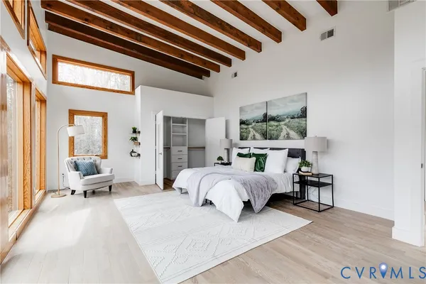 a spacious bedroom with a bed and large windows
