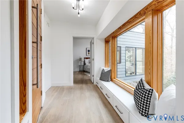 a view of a hallway with wooden floor and furniture